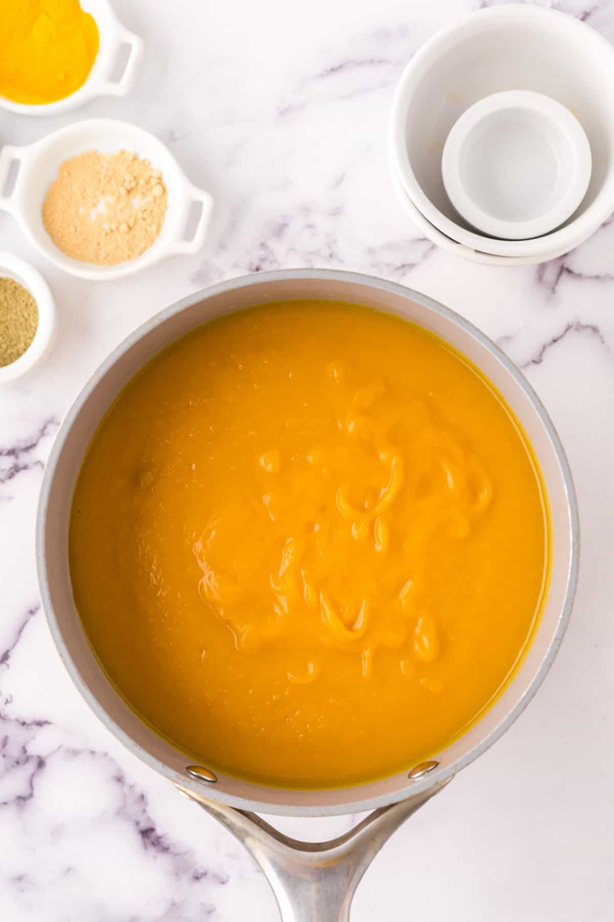 homemade butternut squash soup in progress in a sauce pan.