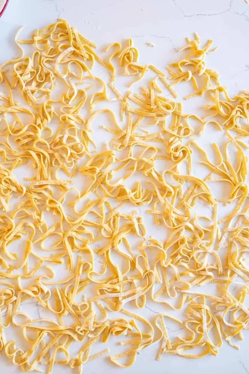 Top view of cut noodles drying on a counter top. 