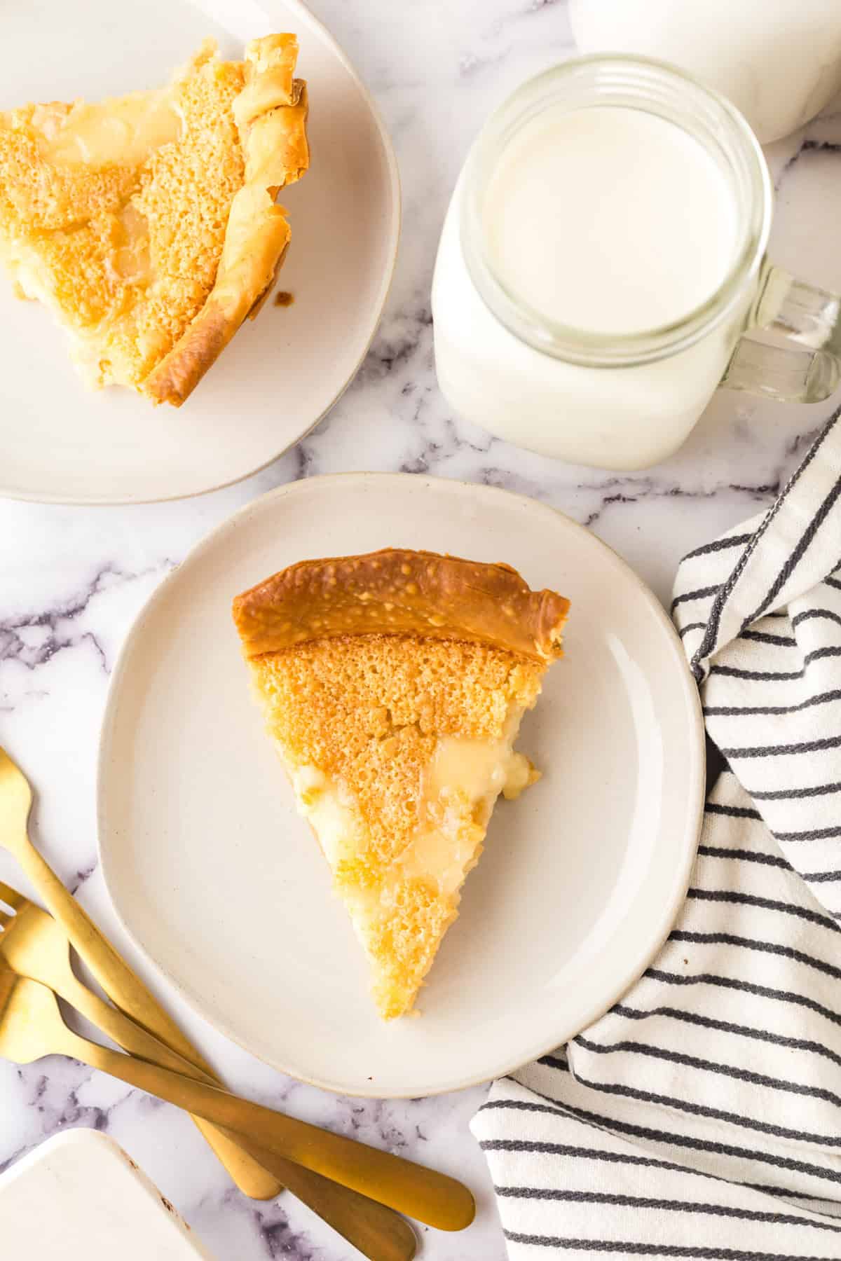 hoosier sugar cream pie slice on a round white plate next to a glass of milk.