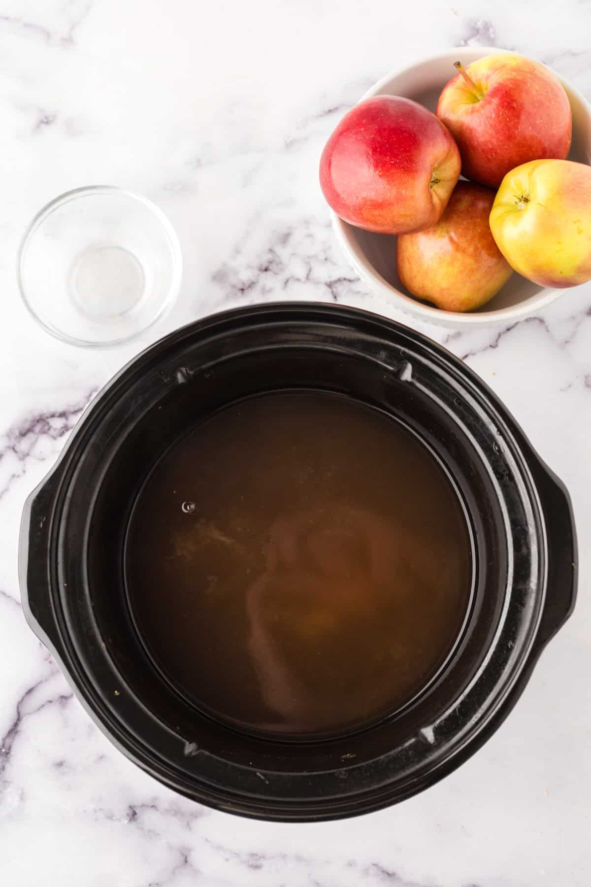 slow cooker apple cider in the pot.