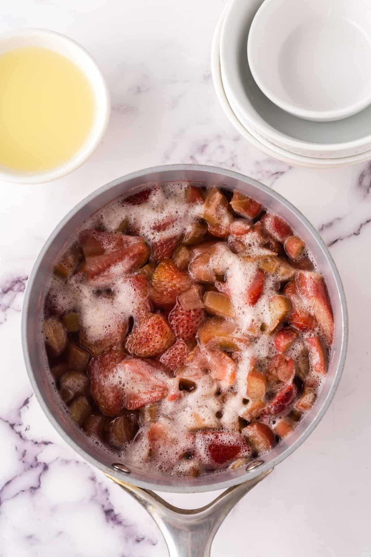 sauce pan reducing down the ingredients to make strawberry rhubarb lemonade.