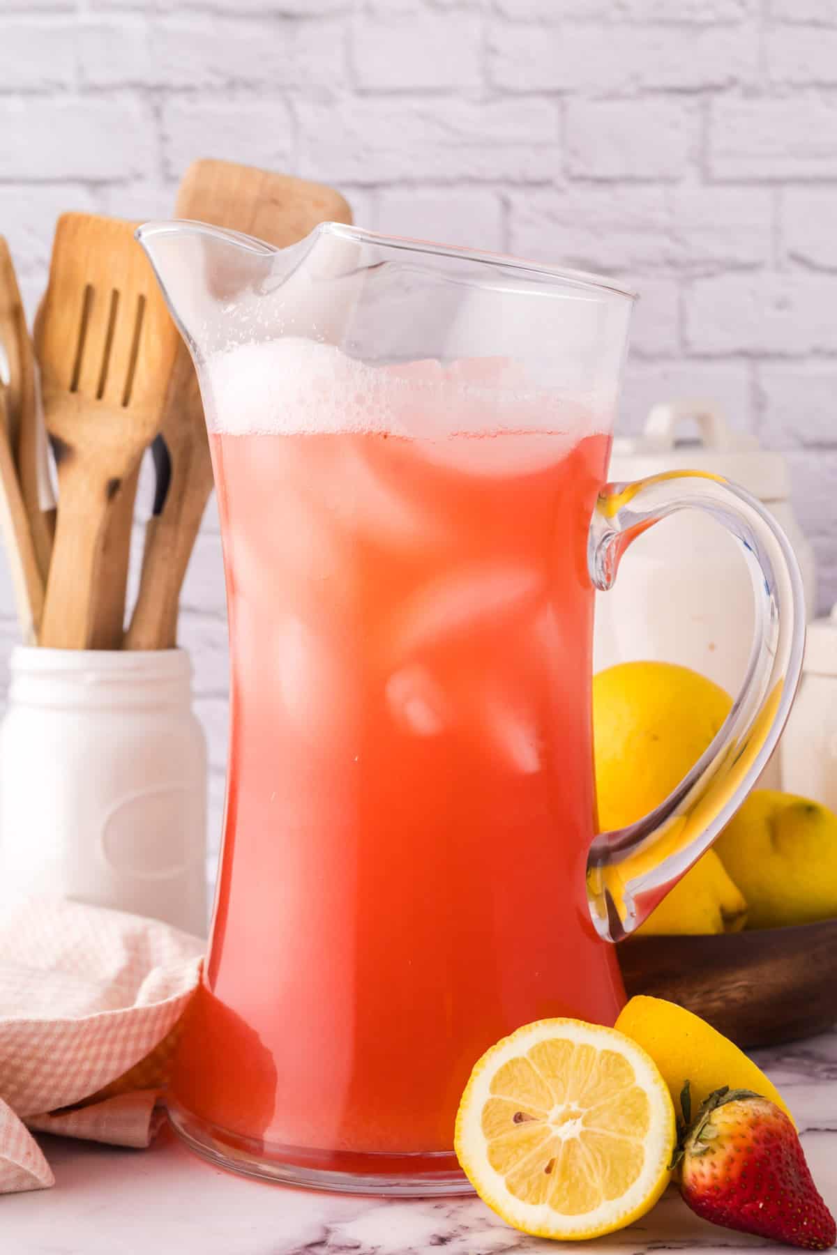 tall glass pitcher filled with fresh strawberry rhubarb lemonade.