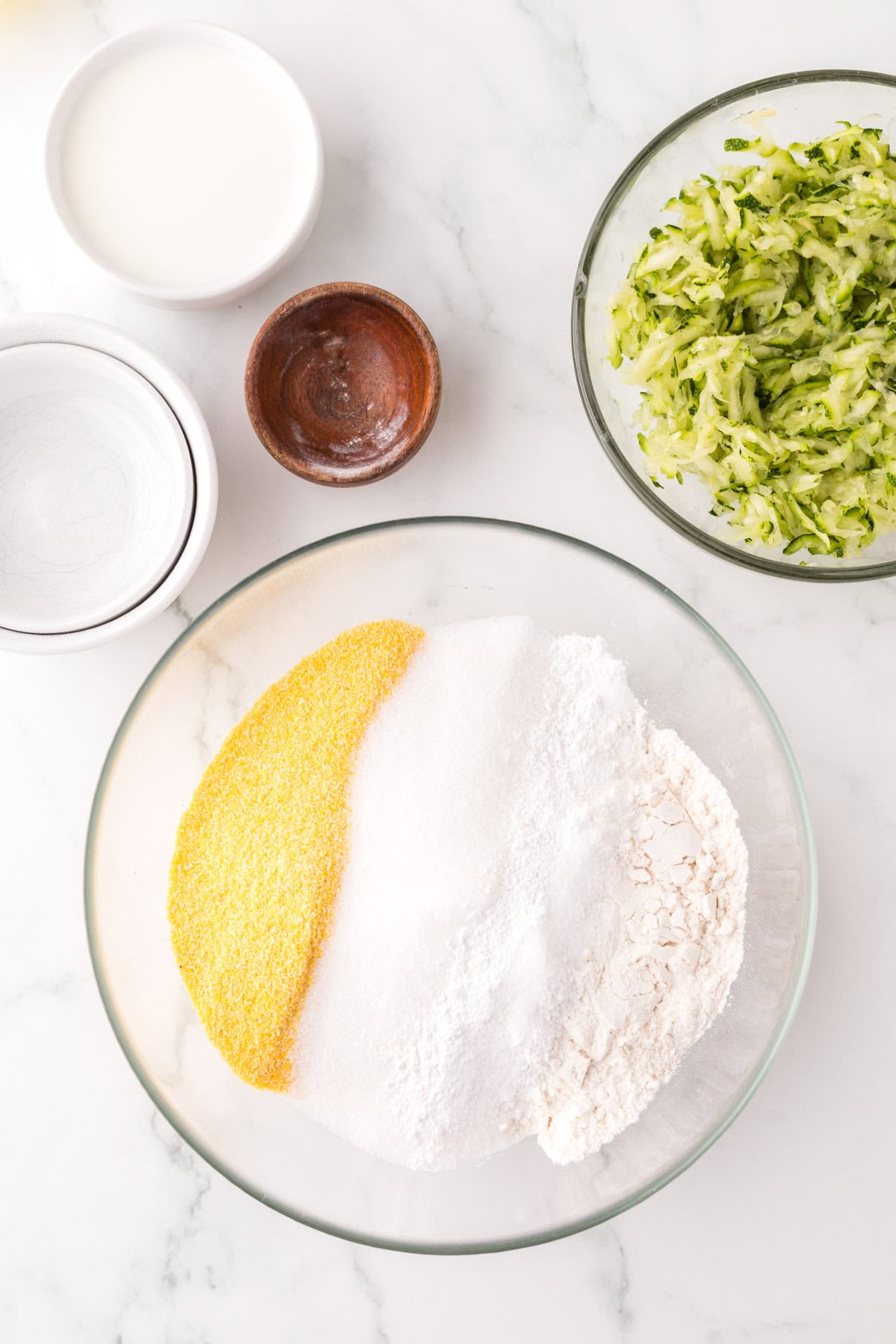 clear mixing bowl in the process of making zucchini cornbread.