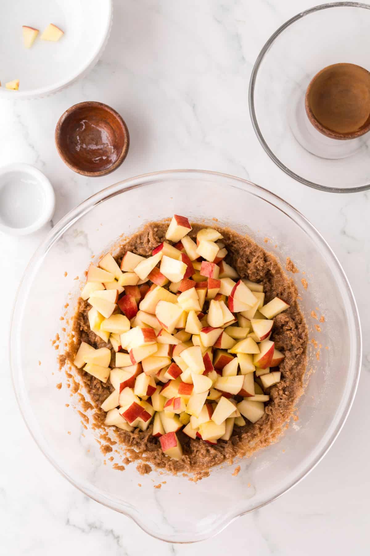 apple cake ingredients in a clear mixing bowl.