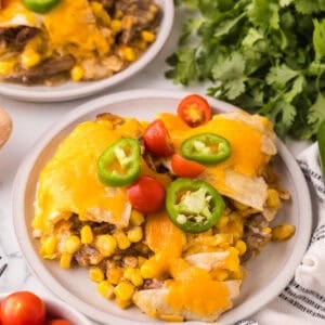 beef and corn enchilada bake on a round white serving plate.