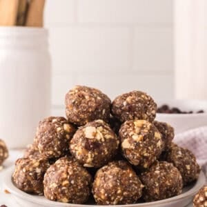 cherry energy balls in a pile on a white plate.