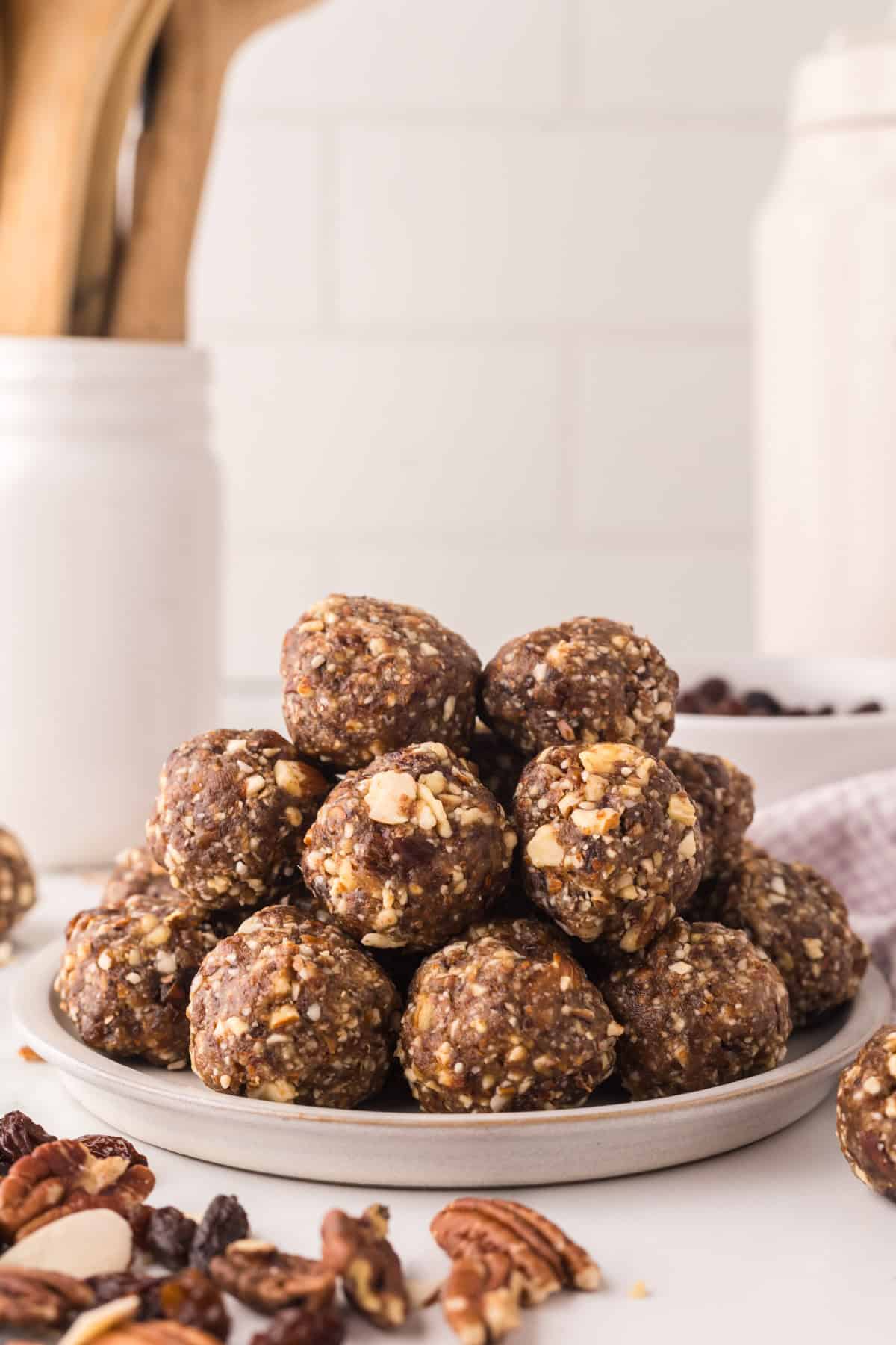 cherry energy balls in a pile on a white plate.