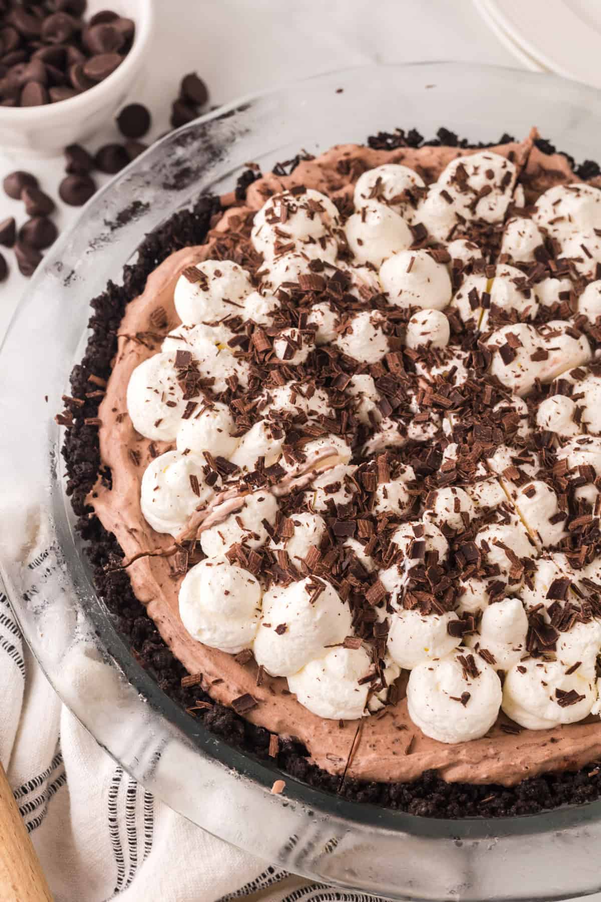 whole chocolate cream pie recipe with dollops of cream and chocolate on top.