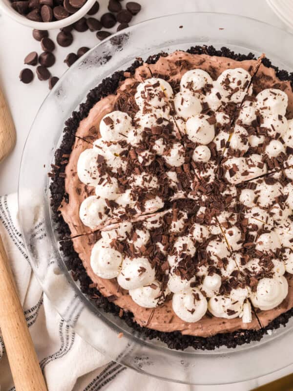 whole chocolate cream pie recipe with dollops of cream and chocolate on top.