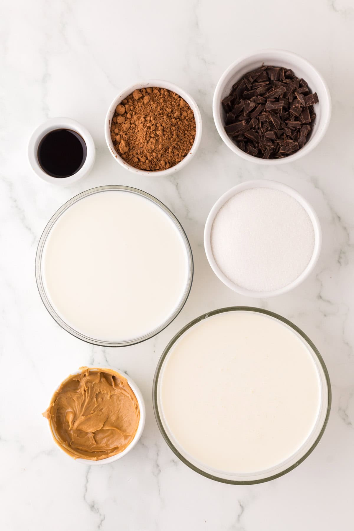 portion bowls each with raw ingredients to make chocolate peanut butter ice cream recipe.