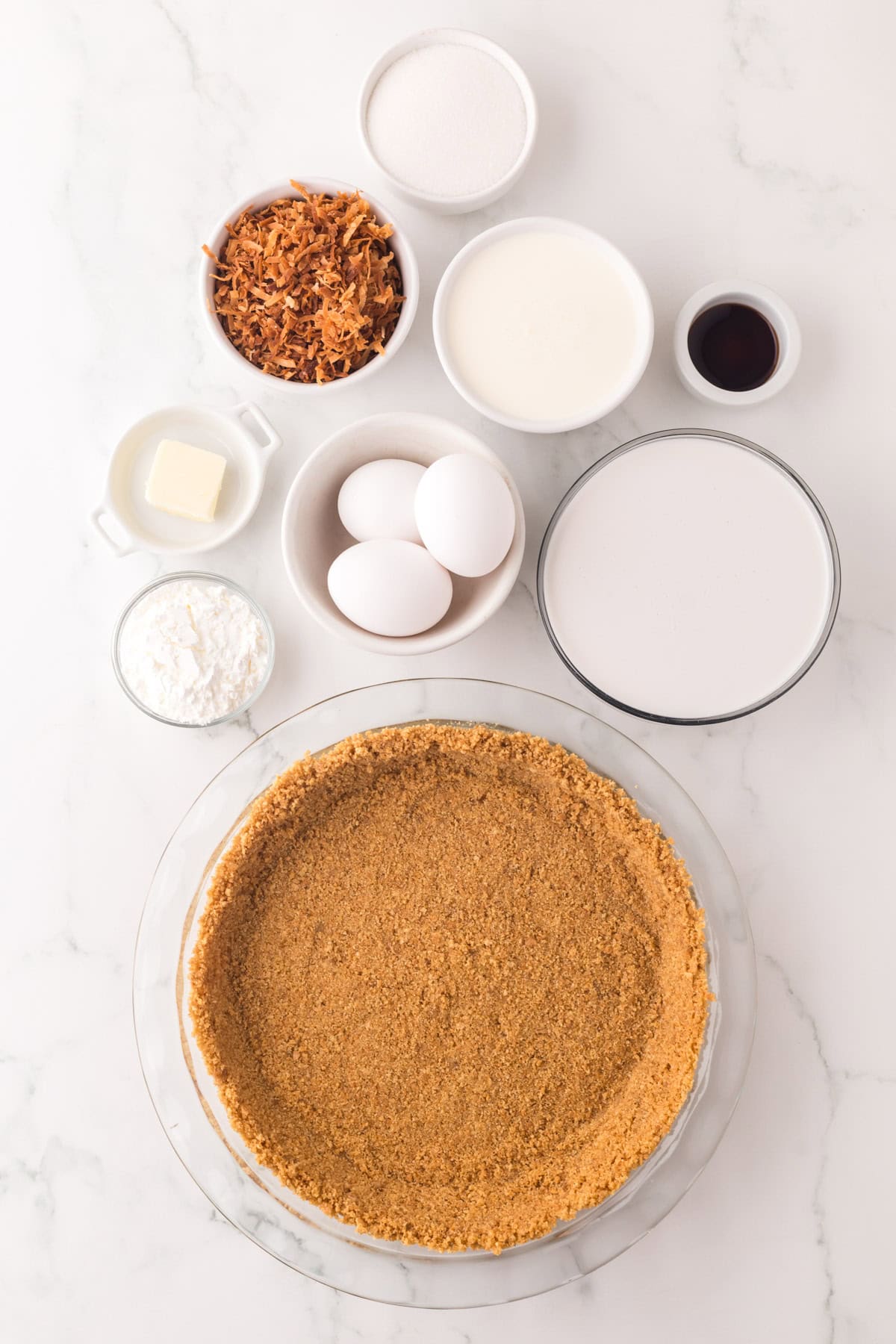 portion bowls each with raw ingredients to make coconut cream pie recipe.