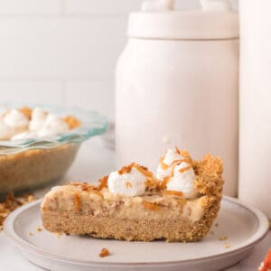 slice of coconut cream pie with dollops of cream on top.