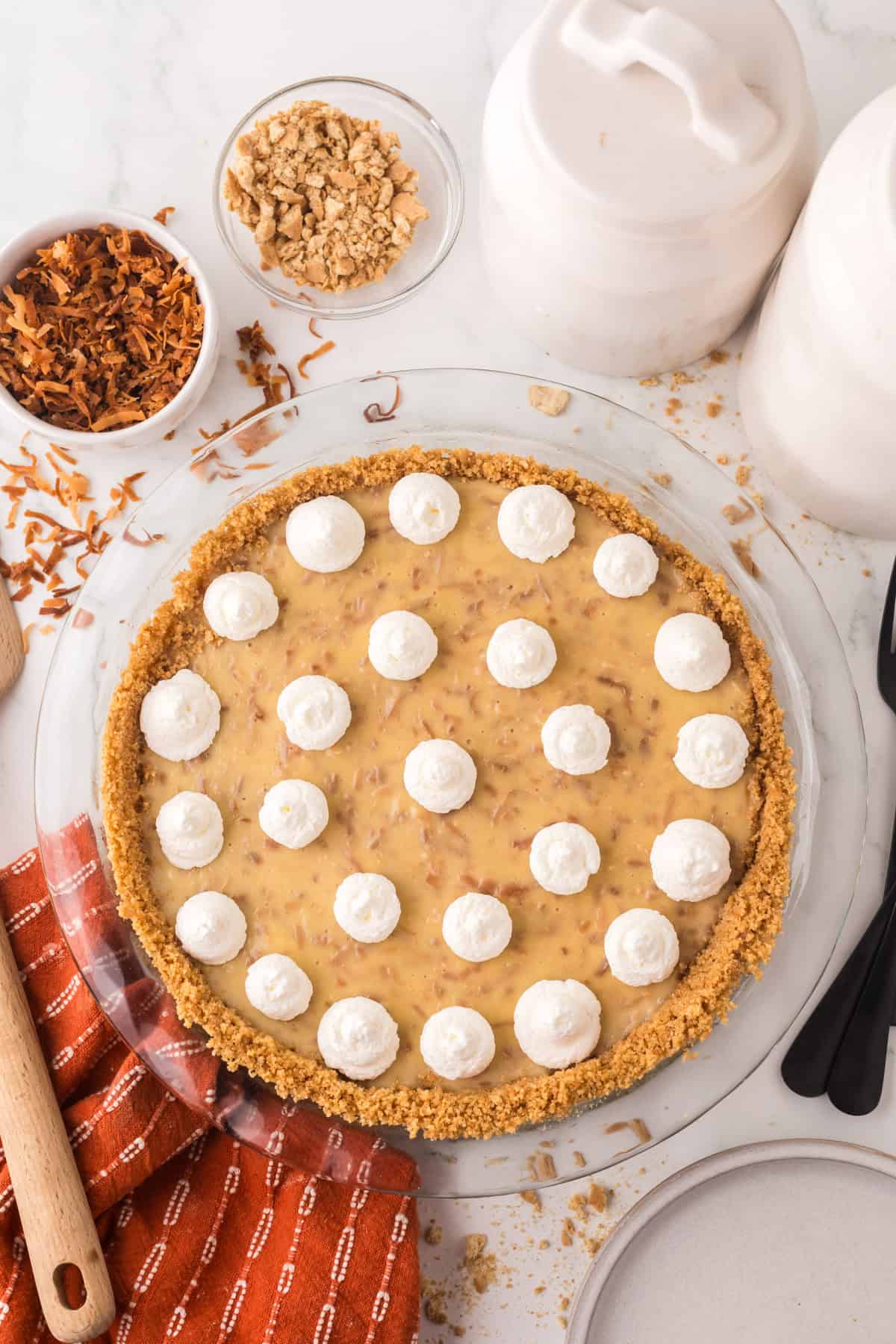 whole coconut cream pie with dollops of cream on top.