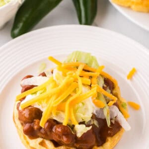 round white plate with cornbread waffles and chili.