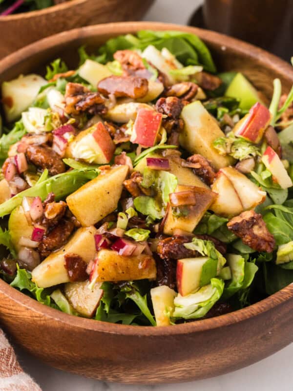 fall salad with pecan and brussel sprouts recipe in wooden mixing bowls.