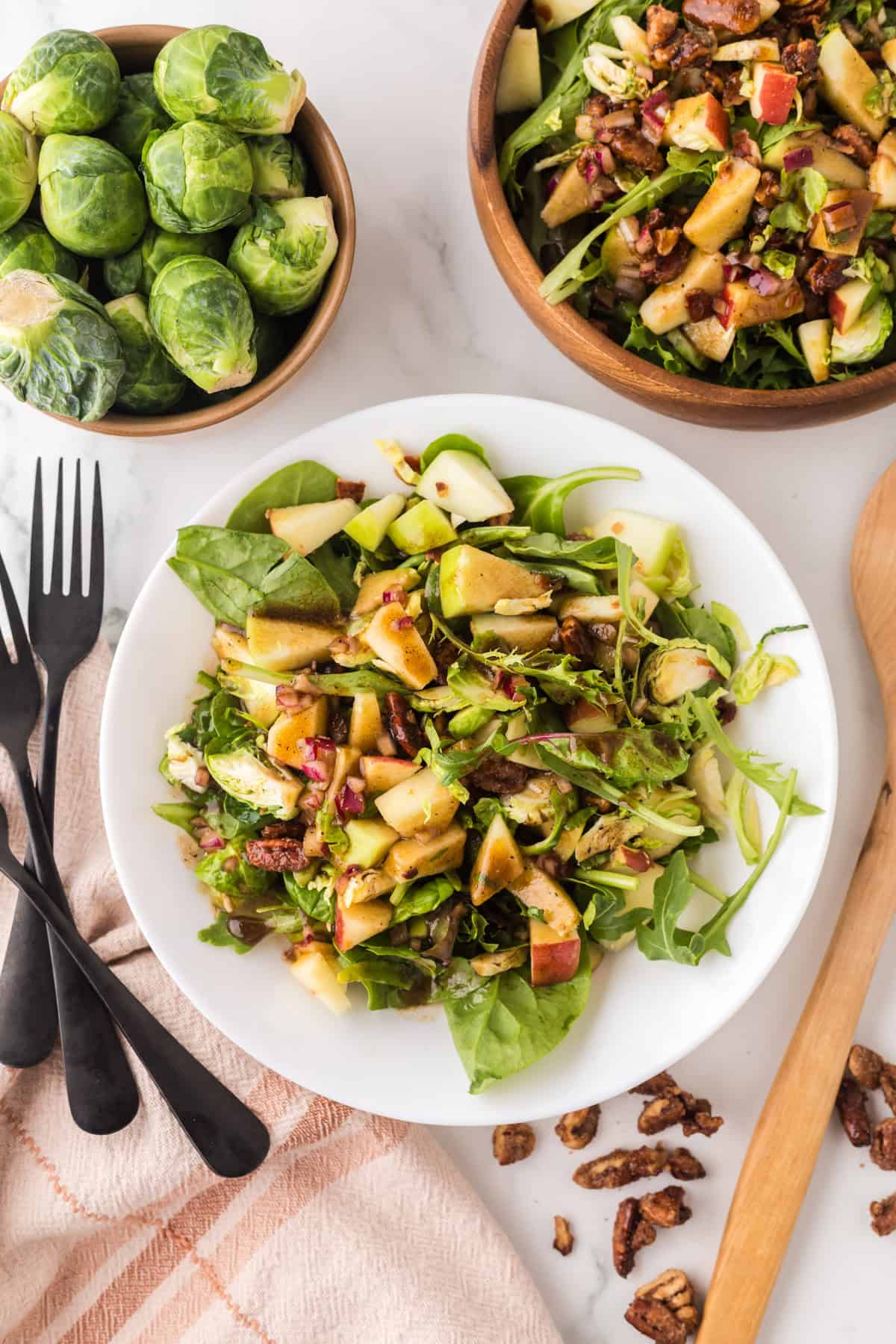 fall salad with pecan and brussel sprouts recipe on a white serving plate.