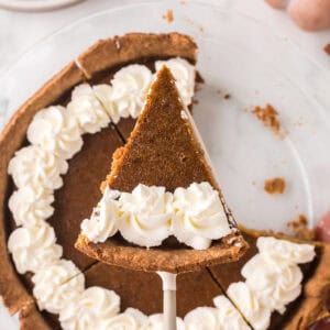 whole homemade healthy pumpkin pie recipe with one slice on a spatula.