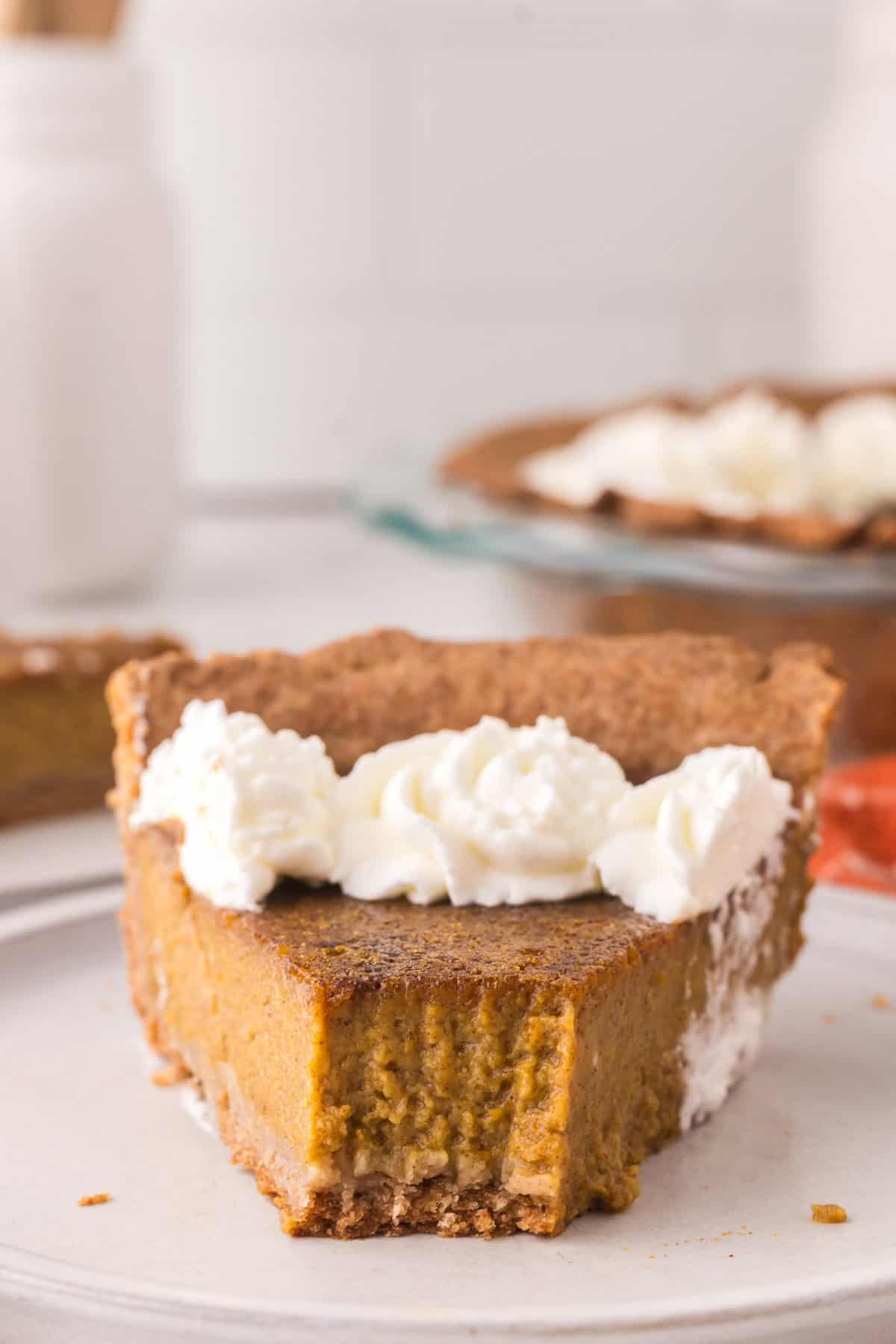 one slice of healthy pumpkin pie on a round plate with a fork bite taken out.