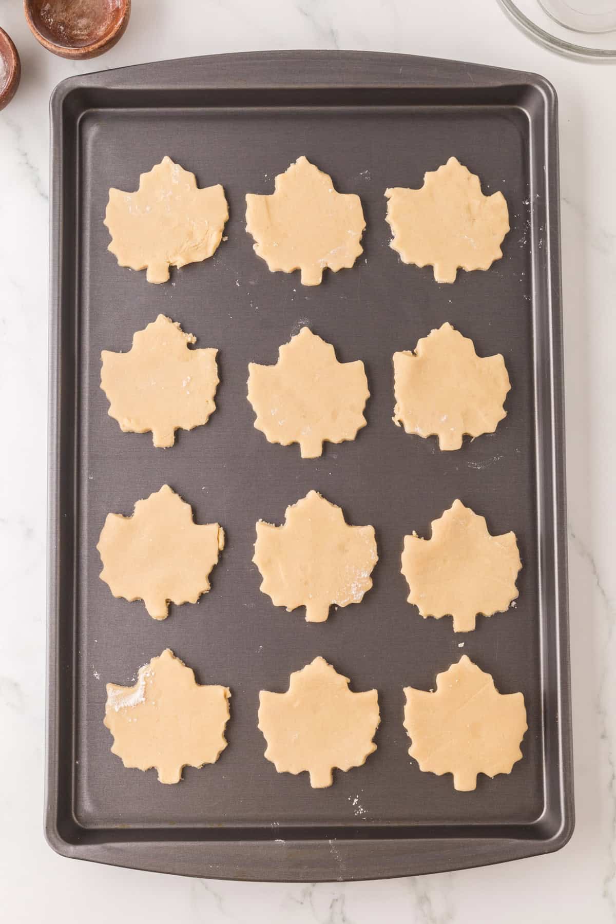 baking tray with maple leaf shaped maple sugar cookie dough ready to bake.