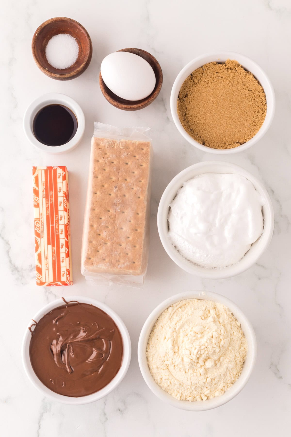 portion bowls each with raw ingredients to make nutella s'mores bars.