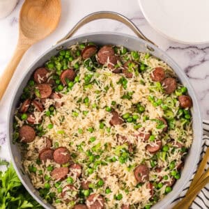 one pot sausage peas and rice in a pan in the progress of cooking.