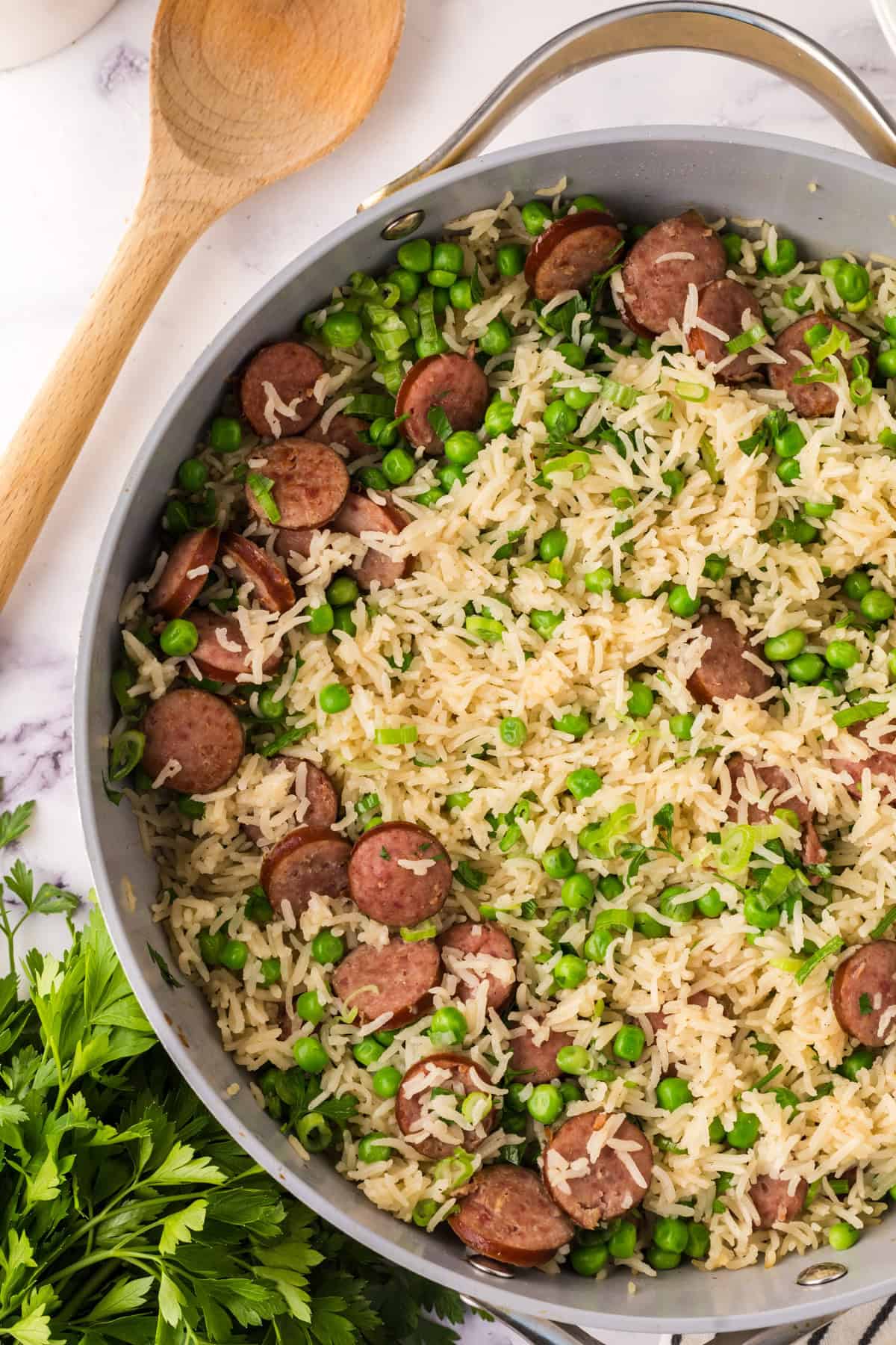 one pot sausage peas and rice in a pan in the progress of cooking.