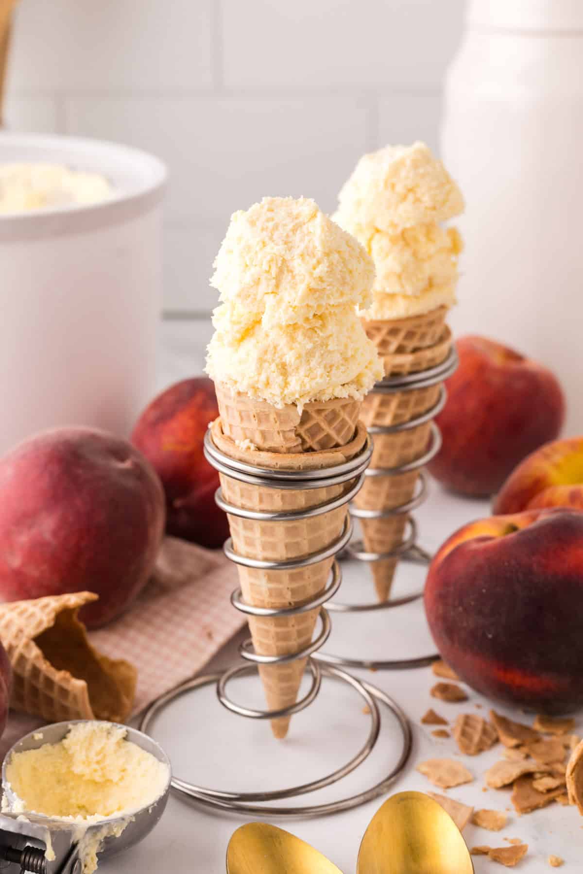 sugar cones with two scoops each of peach ice cream.