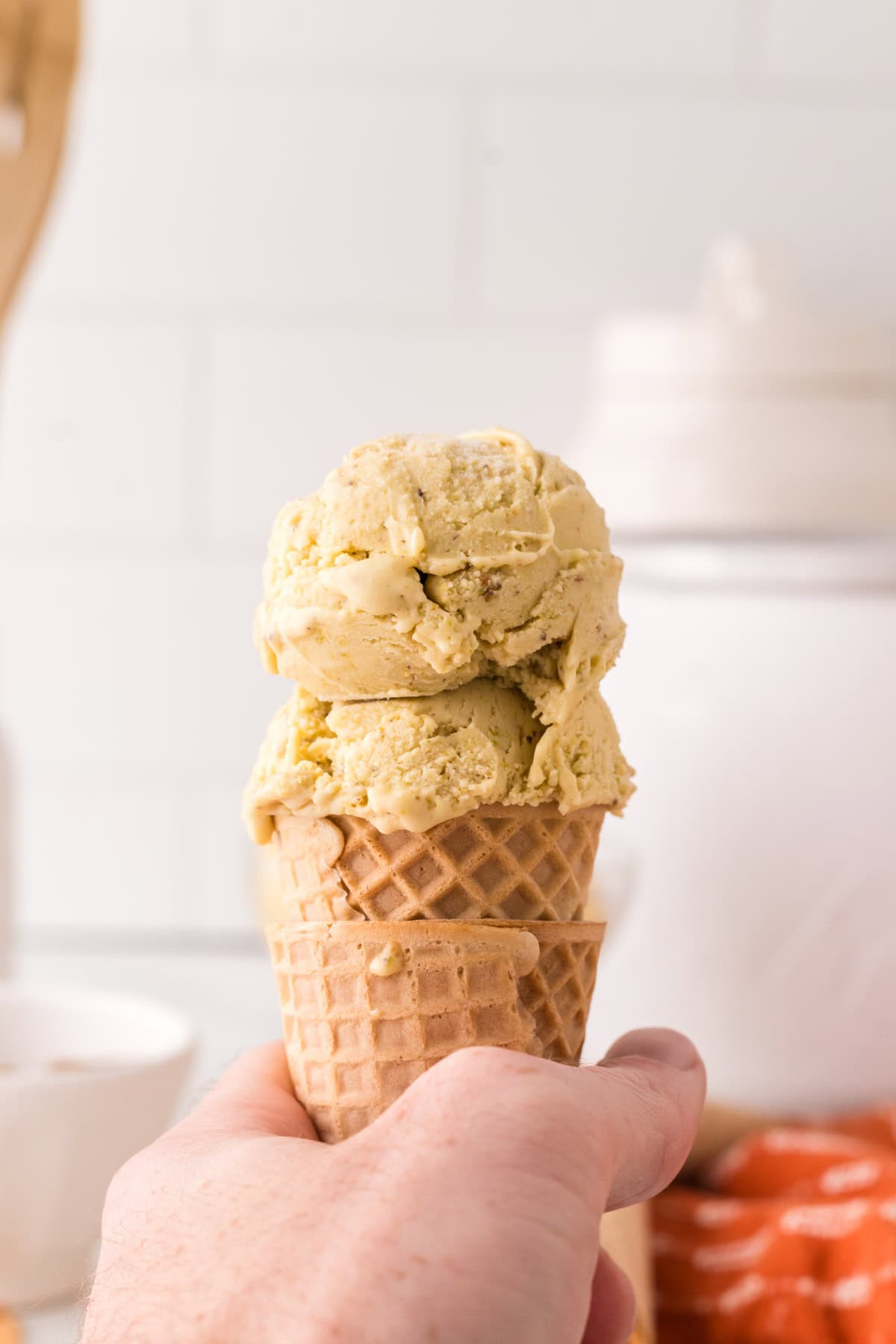 pistachio gelato dripping off a sugar cone.