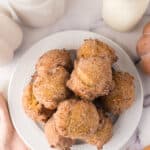 pumpkin donut holes in a pile on a white plate.