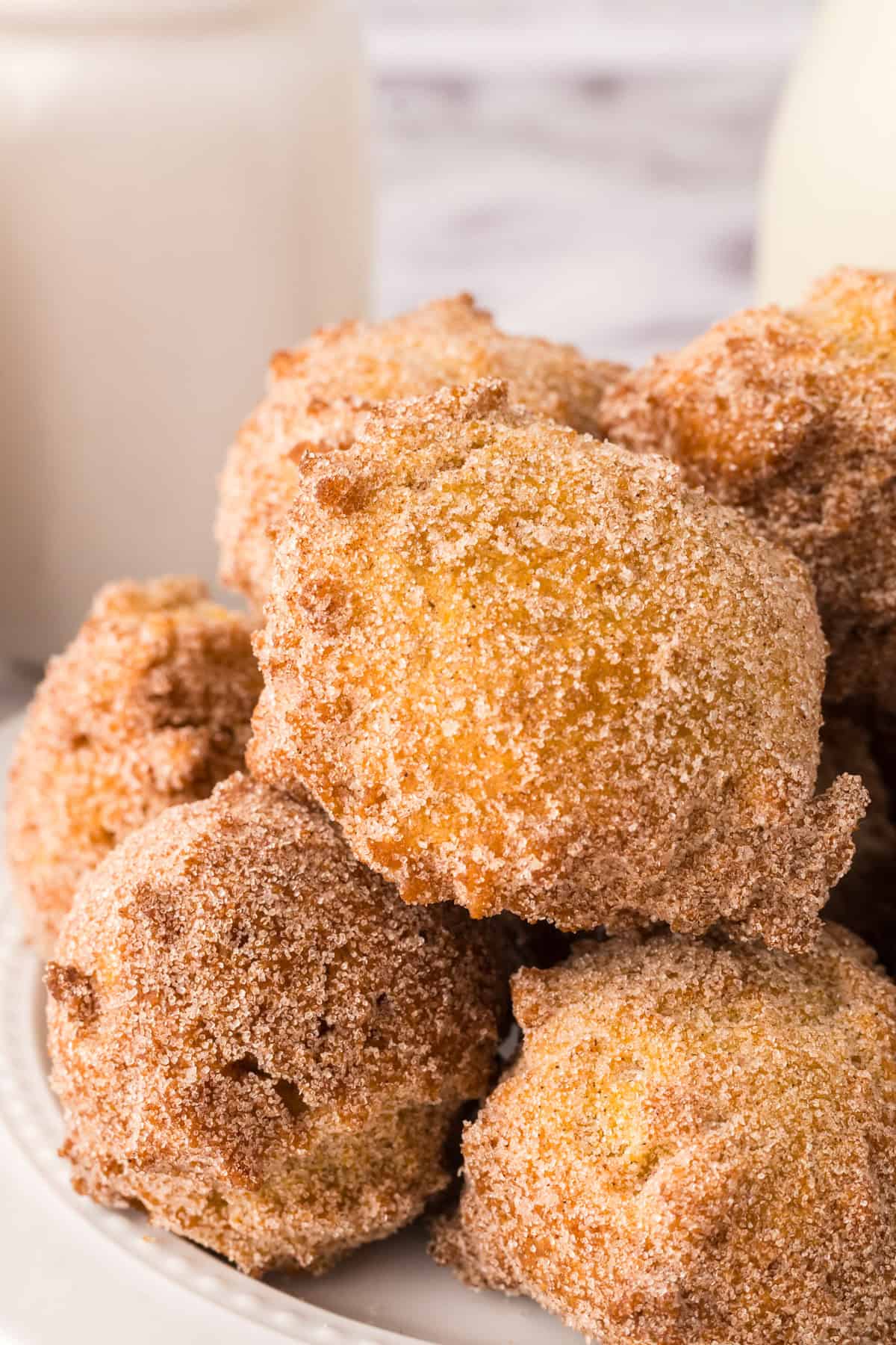 pumpkin donut holes in a pile on a white plate.