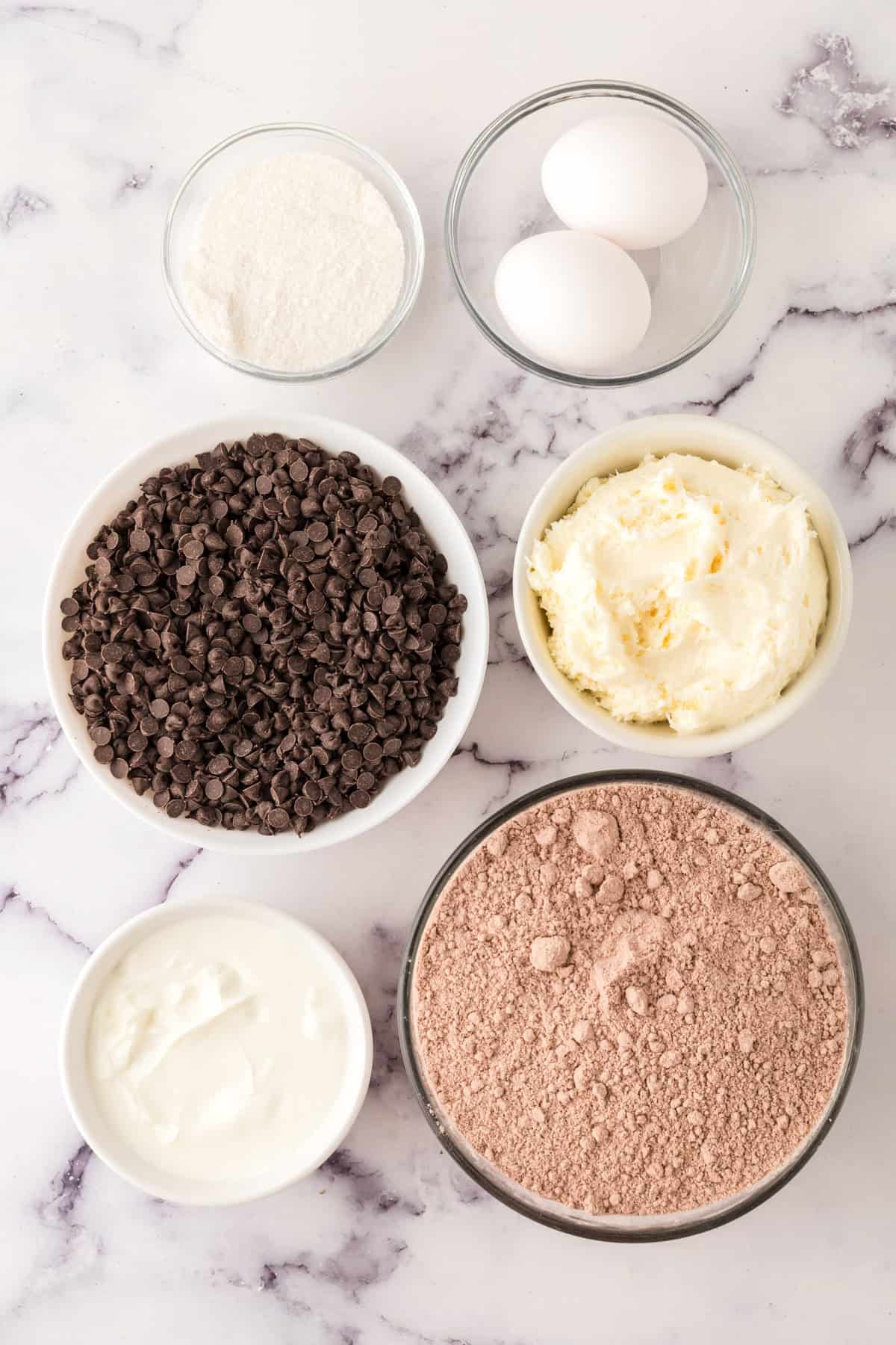 portion bowls each with raw ingredients to make red velvet whoopee pies.