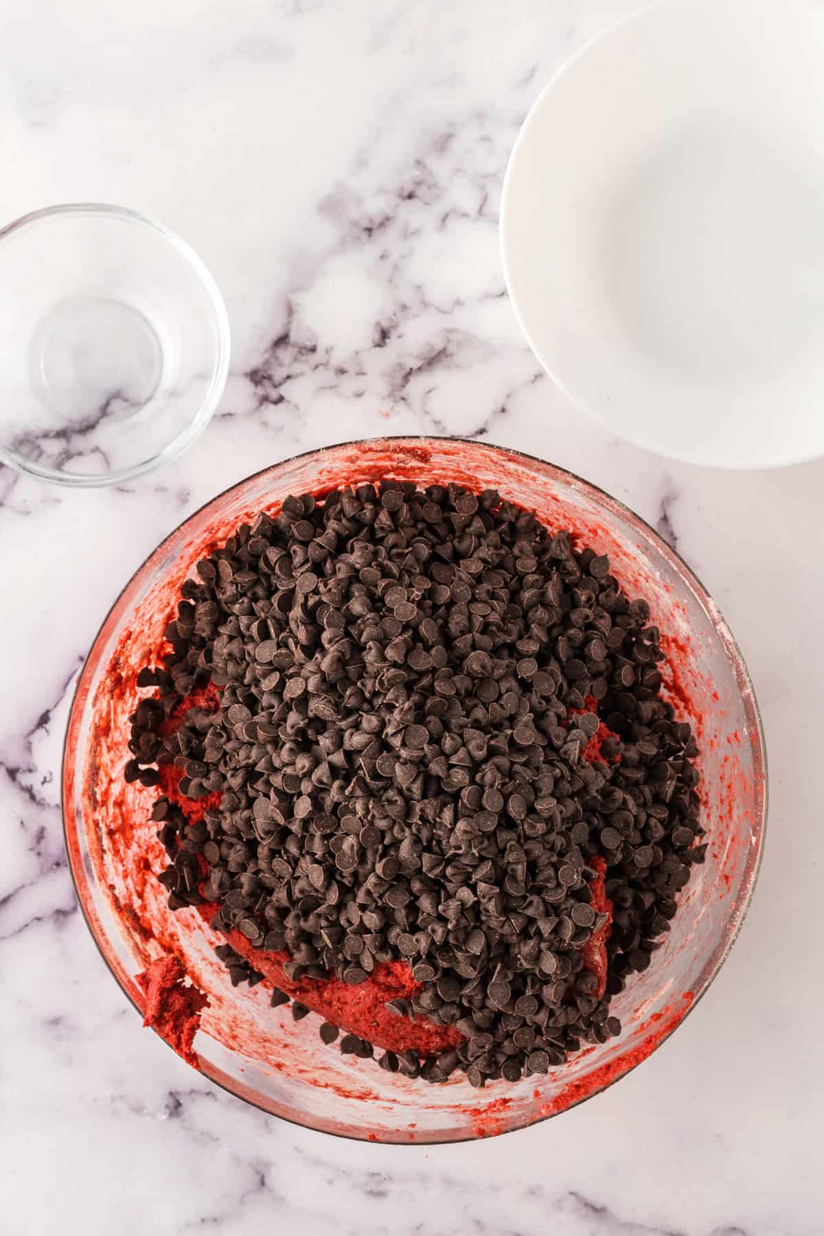 clear mixing bowl in the process of making red velvet whoopee pies.