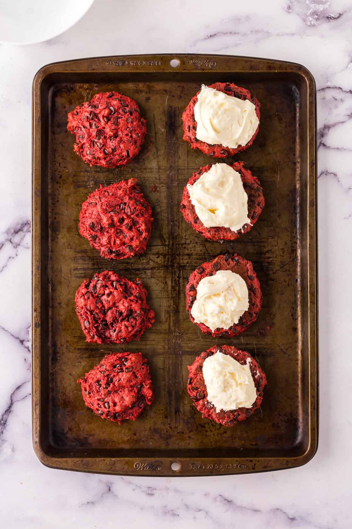 red velvet whoopee pies with frosting on half.