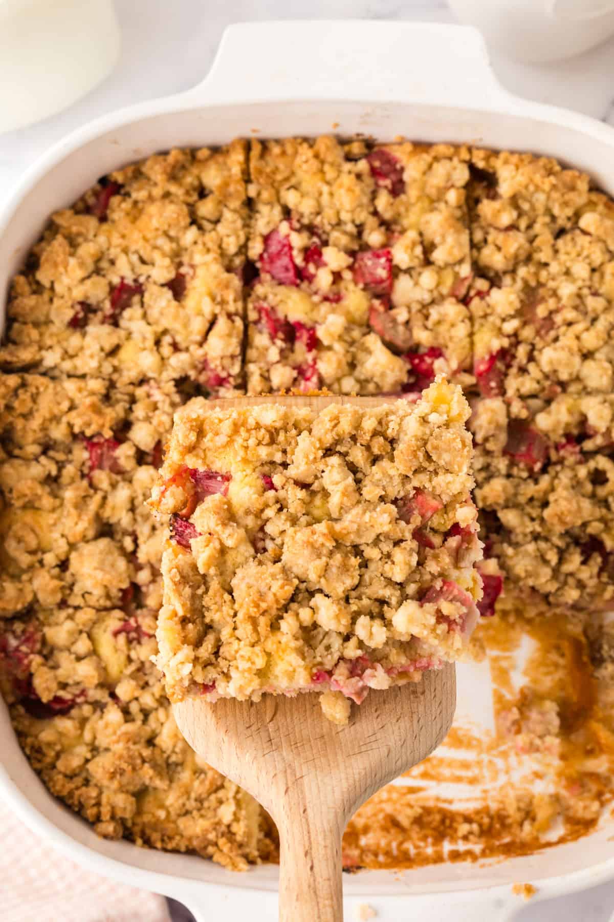 glass dish with baked rhubarb crumb bar recipe cut into squares.