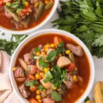 slow cooker beef veggie soup in white serving bowls.