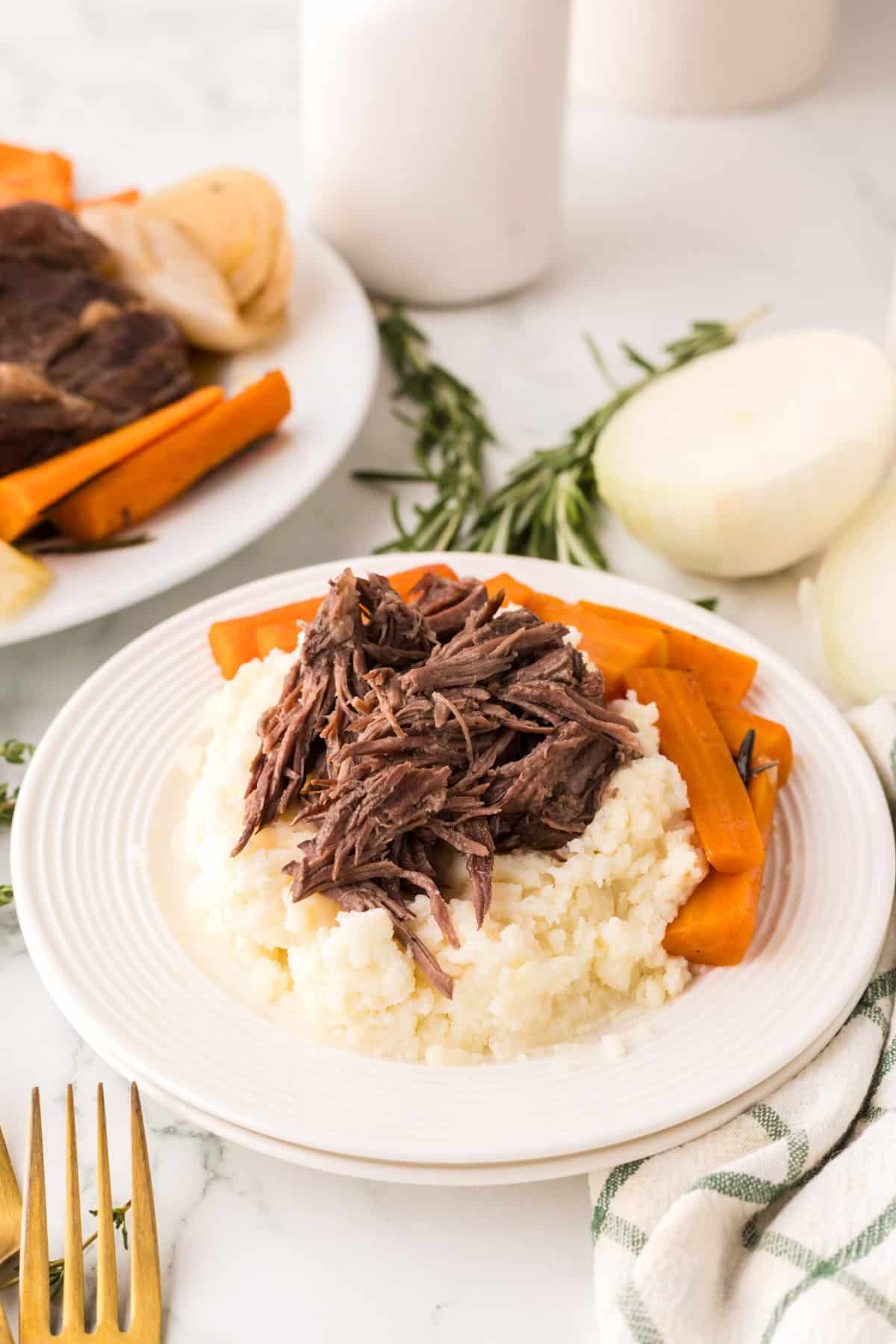 slow cooker pot roast dinner on a round white plate.