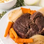 slow cooker pot roast dinner on a round white plate.