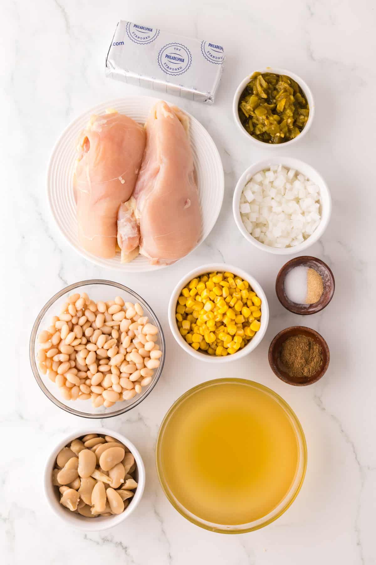 portion bowls each with raw ingredients to make white chicken chili recipe.