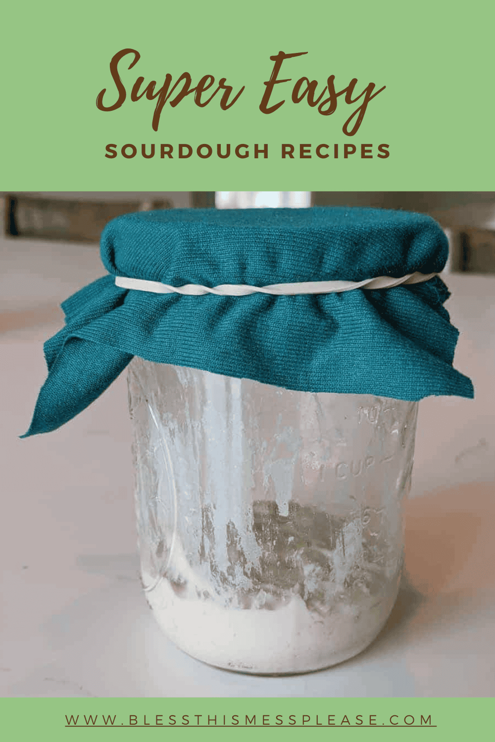 White sourdough starter in a clear jar, with teal fabric with an elastic band around the top, with green and brown text saying "Super Easy Sourdough Recipes".