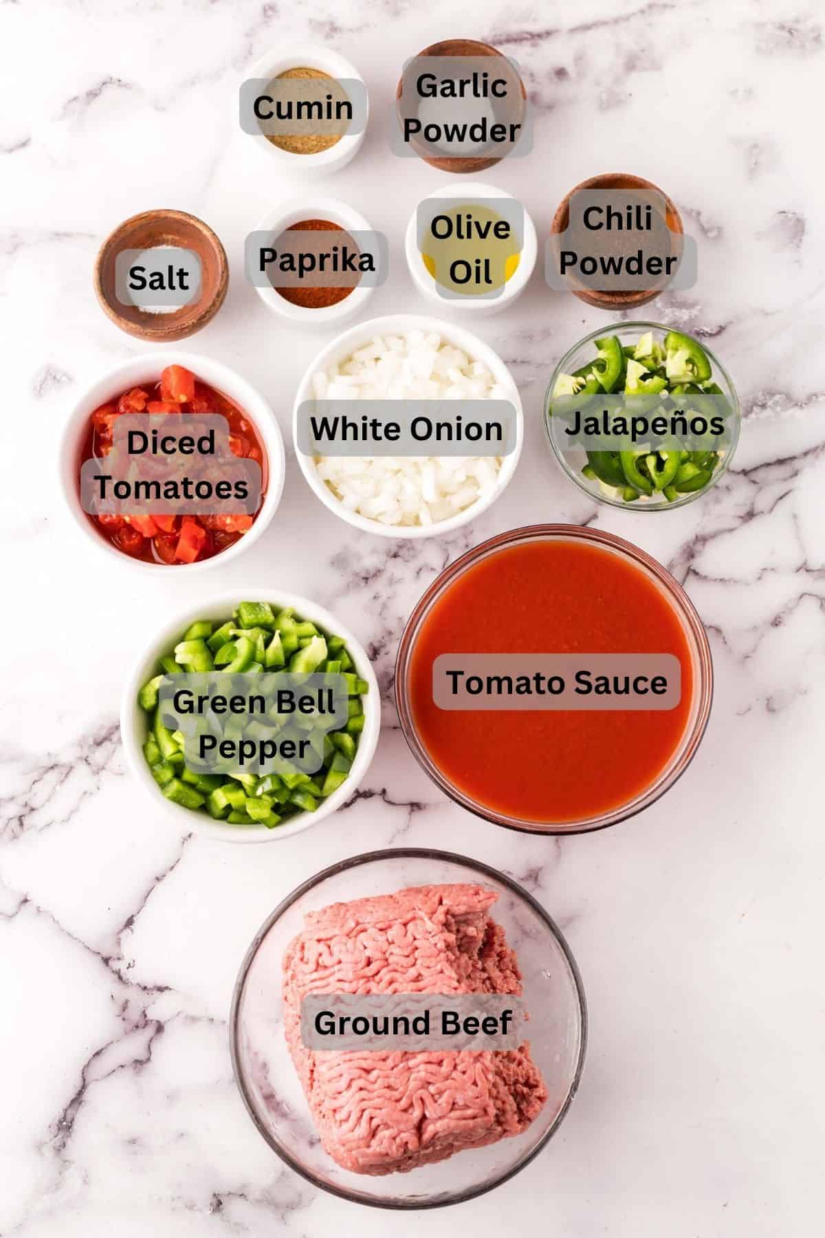 portion bowls each with digitally labeled raw ingredients to make texas chili recipe.