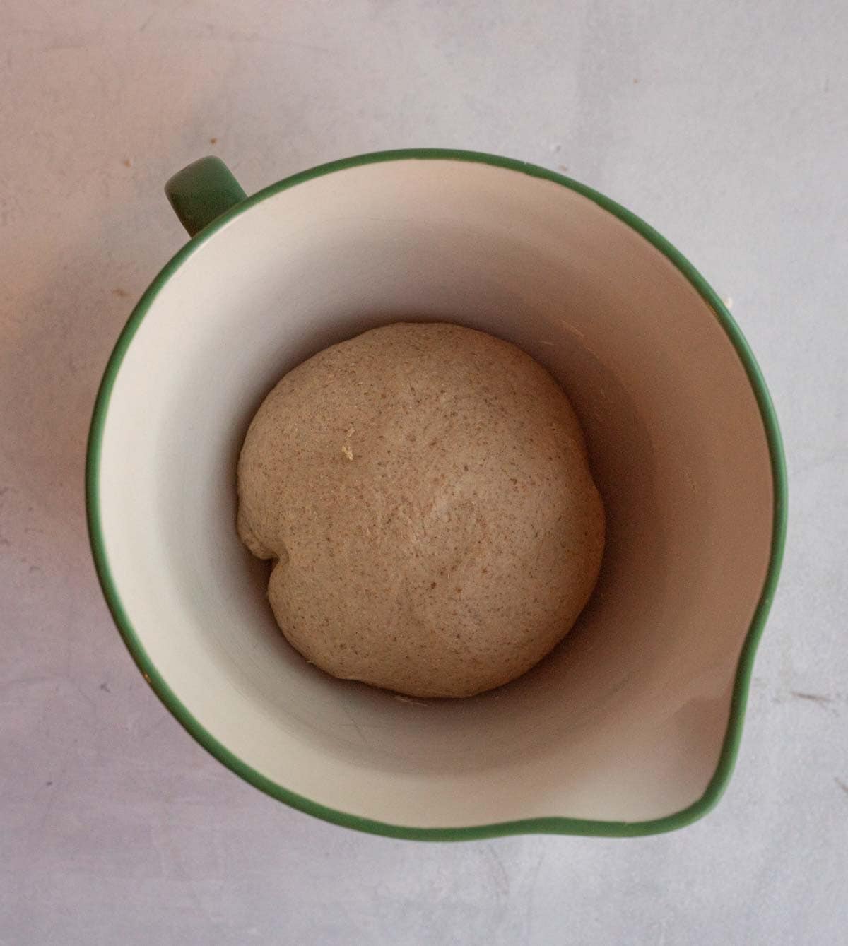 bread dough in green and cream bowl.