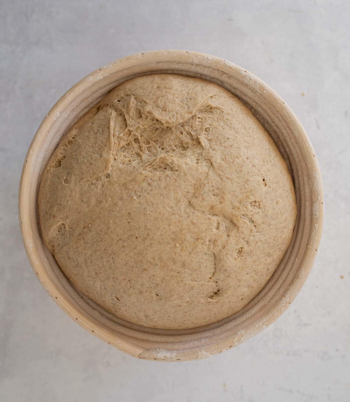 very puffy bread dough in beige bowl.