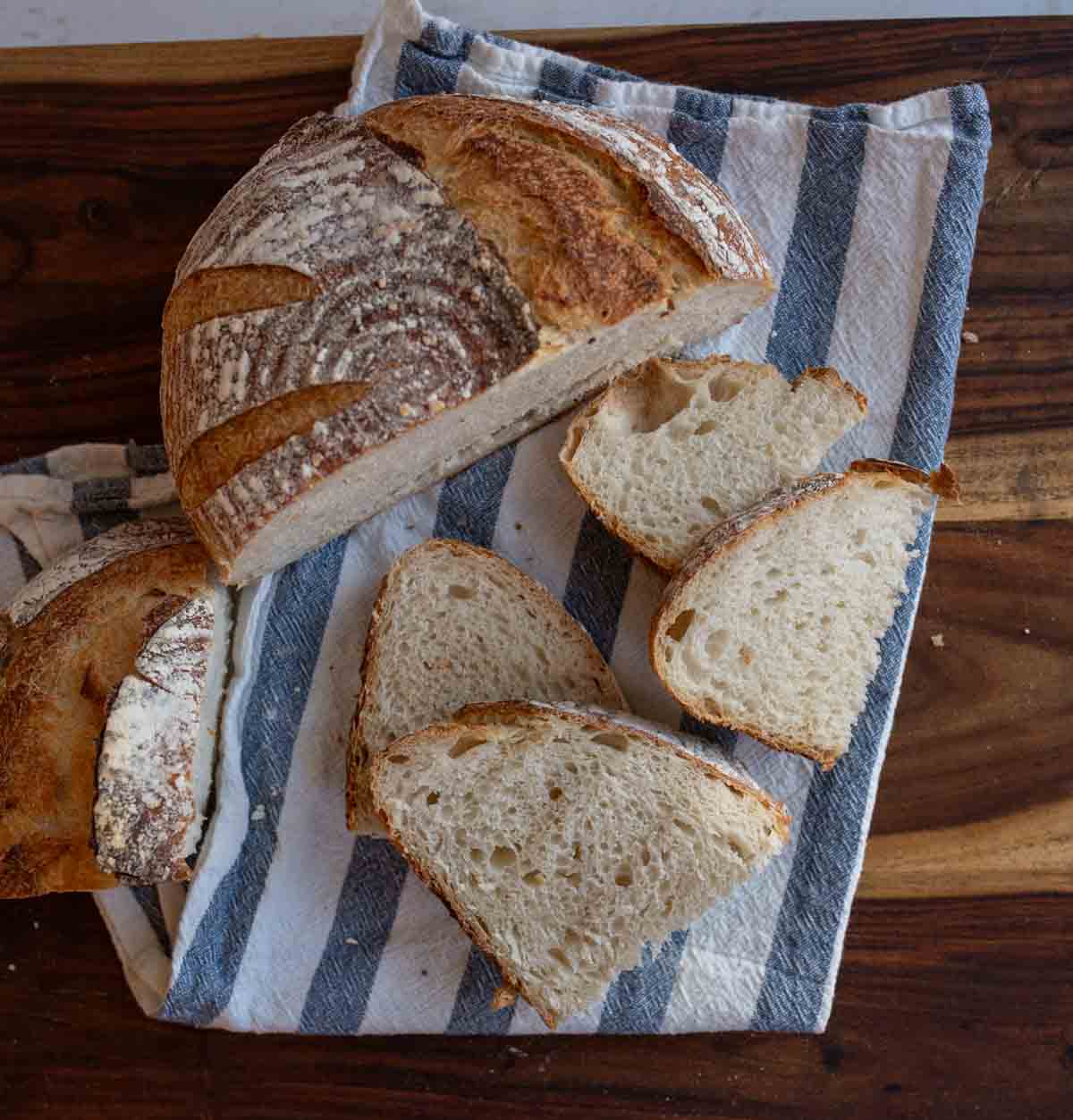 sourdough loaf cut into halves with some slices.