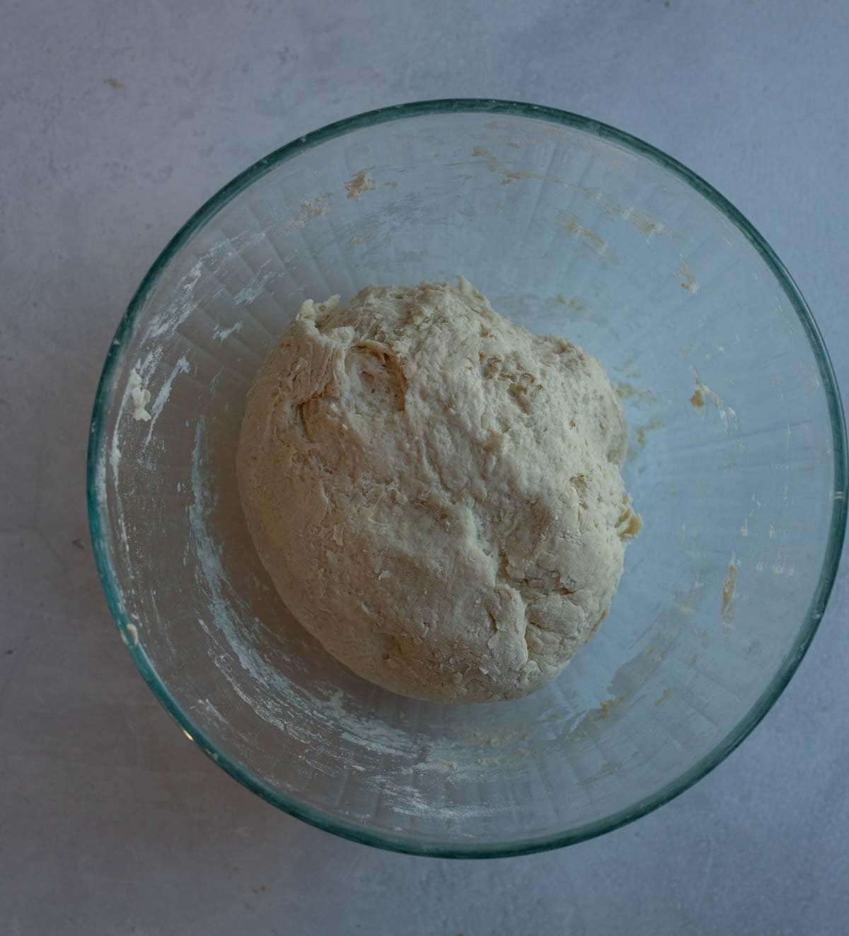 sourdough ball of dough in clear bowl.