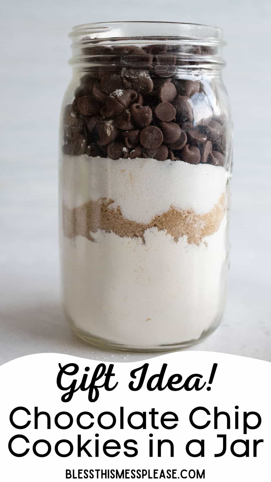 A mason jar filled with layered ingredients for chocolate chip cookies, including flour, brown sugar, and chocolate chips. The text reads, Gift Idea! Chocolate Chip Cookies in a Jar.