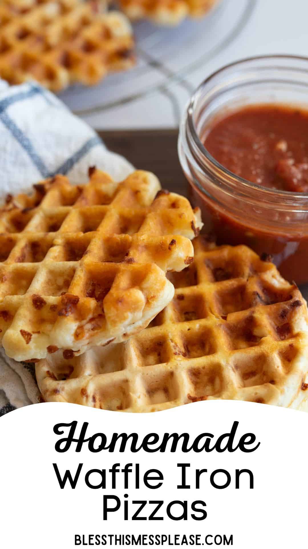 Close-up of three waffle iron pizzas on a cloth napkin, with a jar of marinara sauce in the background. Text at the bottom reads Homemade Waffle Iron Pizzas with a website URL.